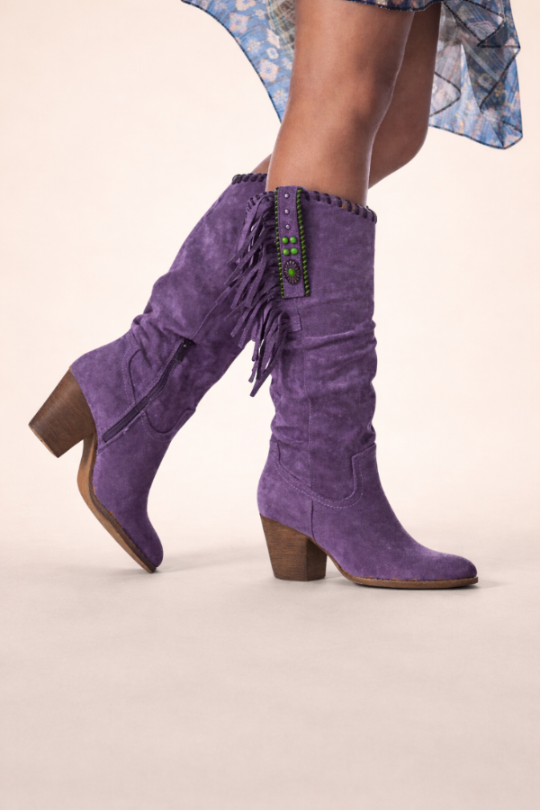 Purple suede boots with fringe details on a neutral background