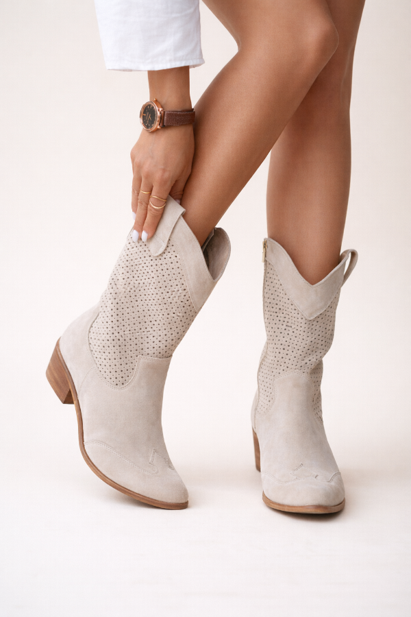 White cowboy boots worn with a neutral background